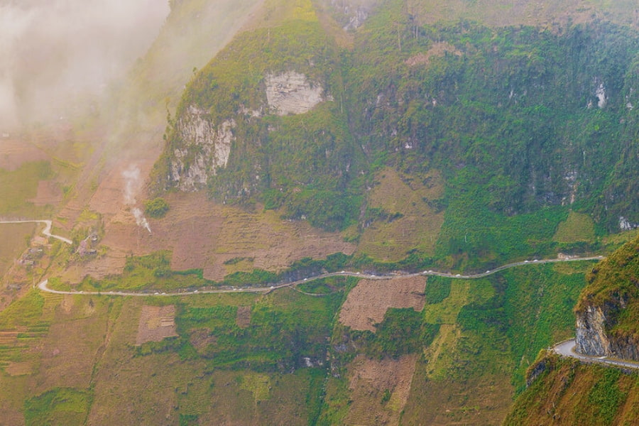 Scenic Ha Giang mountain pass road winding through dramatic green valleys